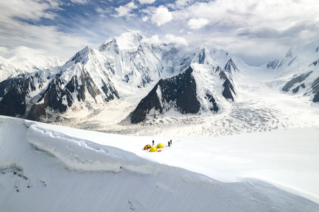 a group of people standing on top of a snow covered slope