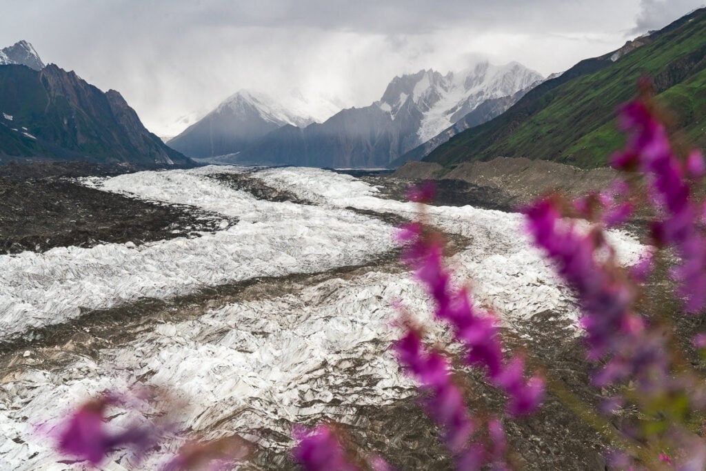 a river running through a valley with mountains in the background