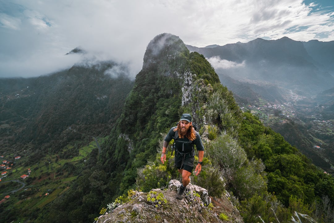 a man hiking up a mountain with a backpack.